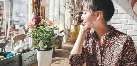 dame die geniet van haar rozen in pot voorzien van een plantsensor