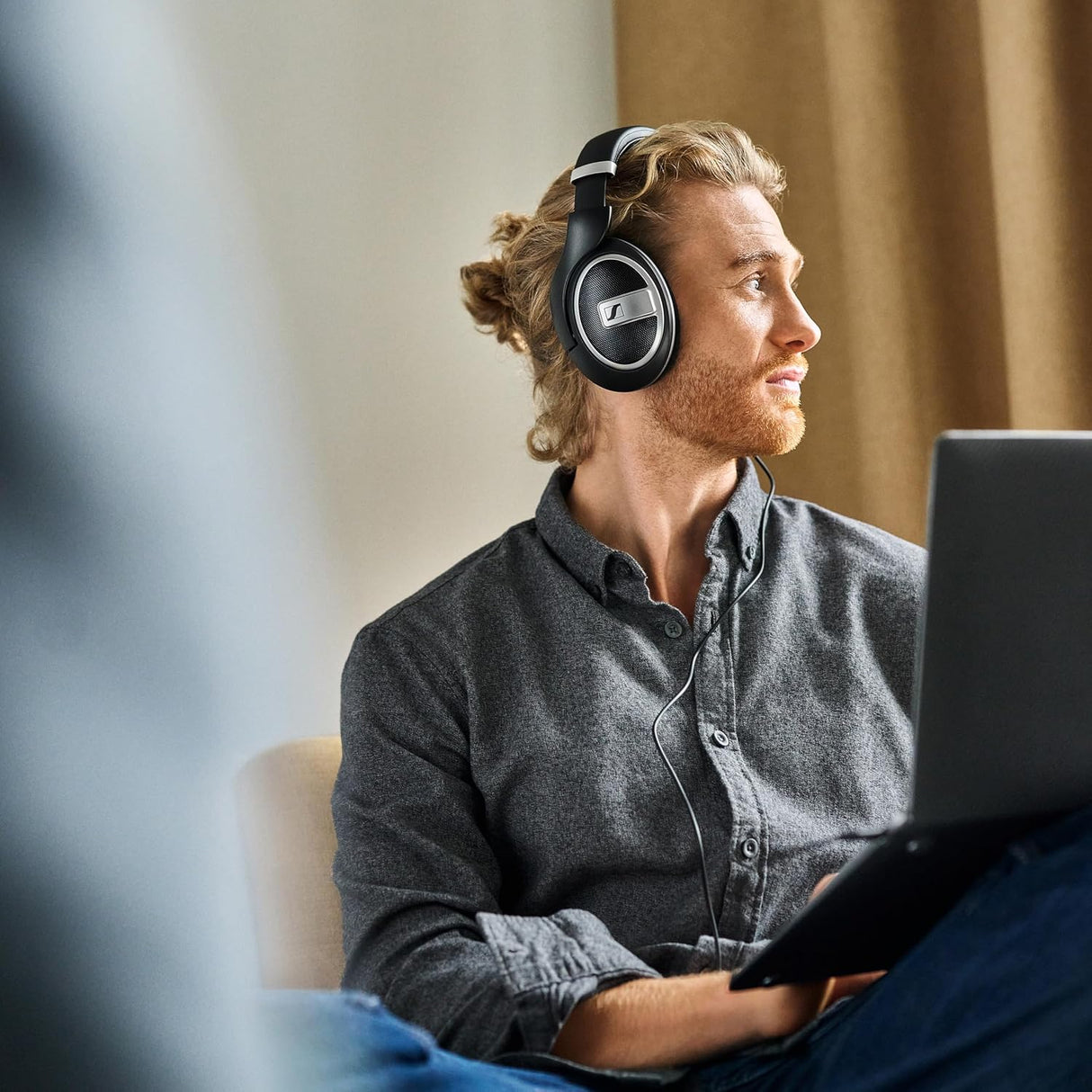 Sennheiser HD 599 Special Edition, hoofdtelefoon met open achterkant zwart  gedragen door man achter laptop.